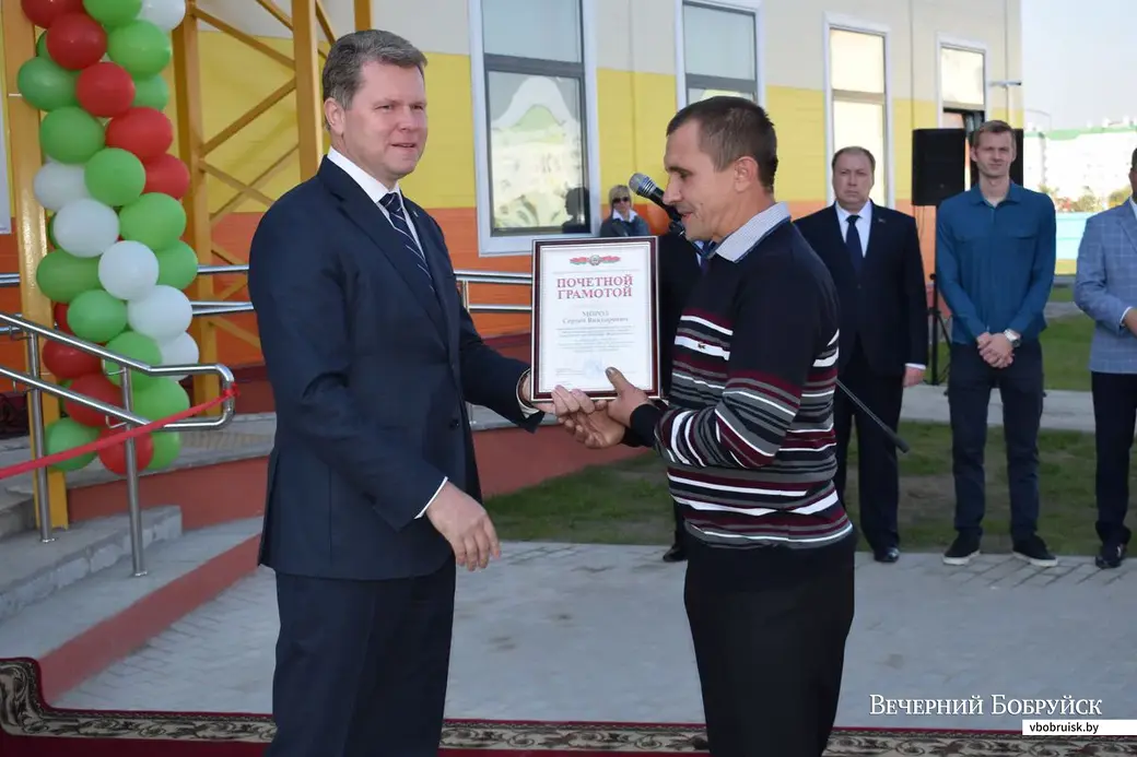 Председатель Бобруйского горисполкома Александр Студнев награждает монтажника Сергей Мороза.