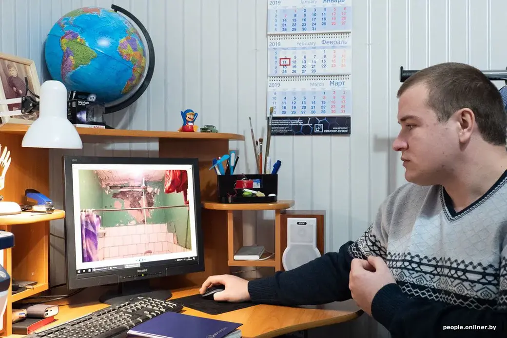 Андрей листает снимки комнаты на компьютере.