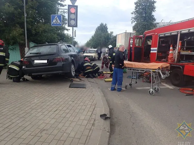 Спасатели извлекают женщину-пешехода из-под колес автомобиля. Фото: МЧС