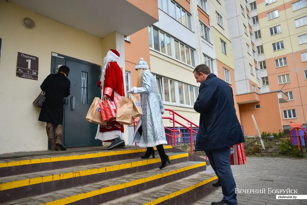 20.12.2019. Дед Мороз со Снегурочкой и директор ОАО «Красный Пищевик» Сергей Анюховский идут в гости в многодетную семью Светланы Филипчик.
