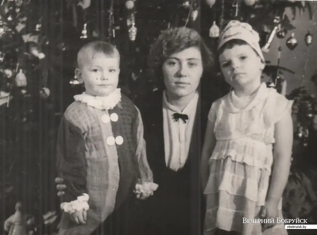 3-летний Юра Самак с воспитательницей Людмилой Михайловной (не уверен, что имя помнит верно) и девочкой Лидой из группы. «На мне костюм то ли Петрушки, то ли