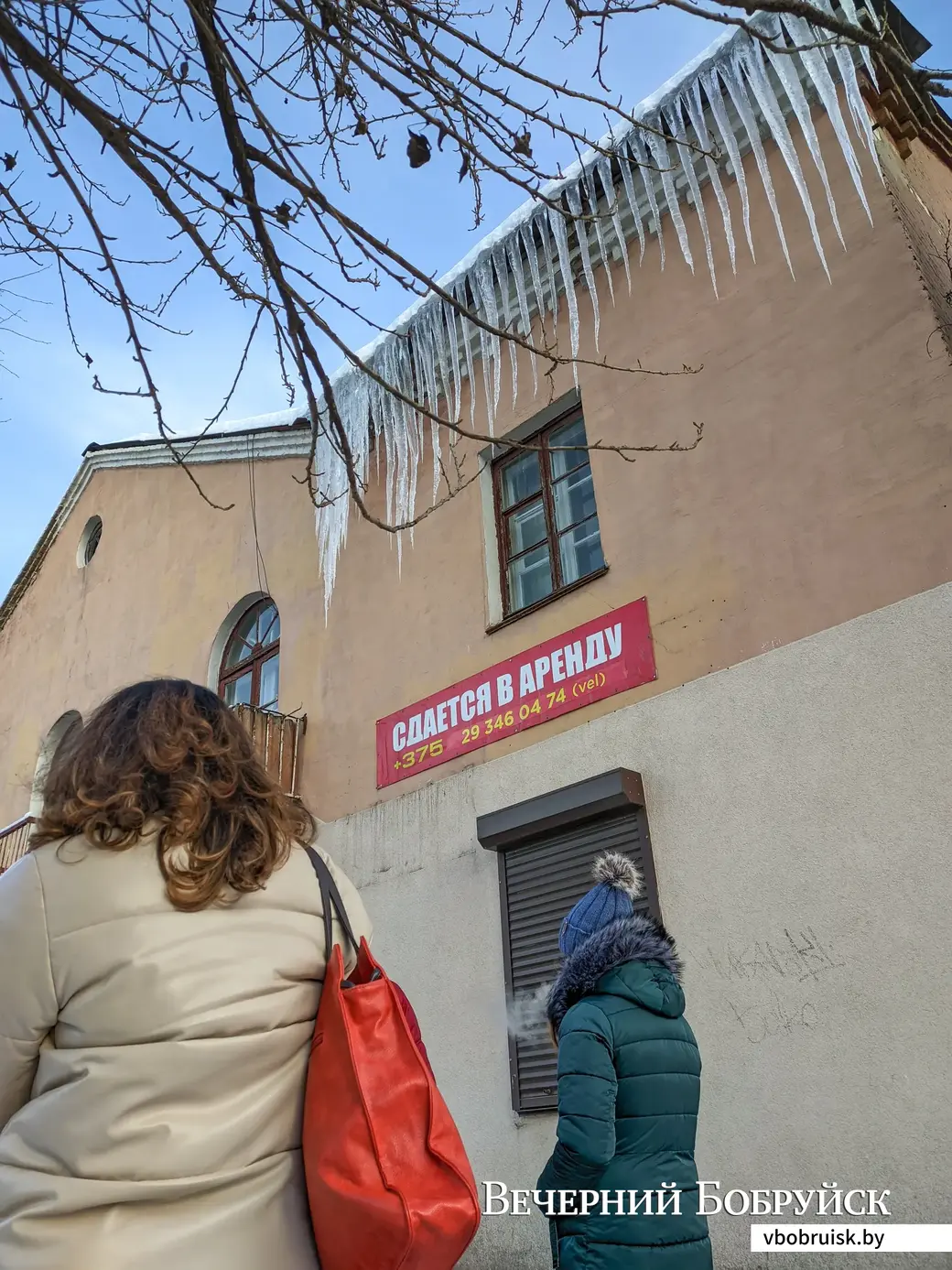 02.12.2022. Бобруйск. Люди стоят в очереди под нависающим карнизом из гигантских сосулек