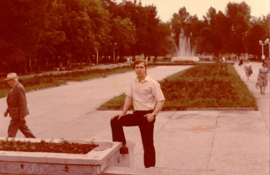 Отец Леонид Петрович Старовойтов на фоне фонтана на площади, примерно середина 1980-ых